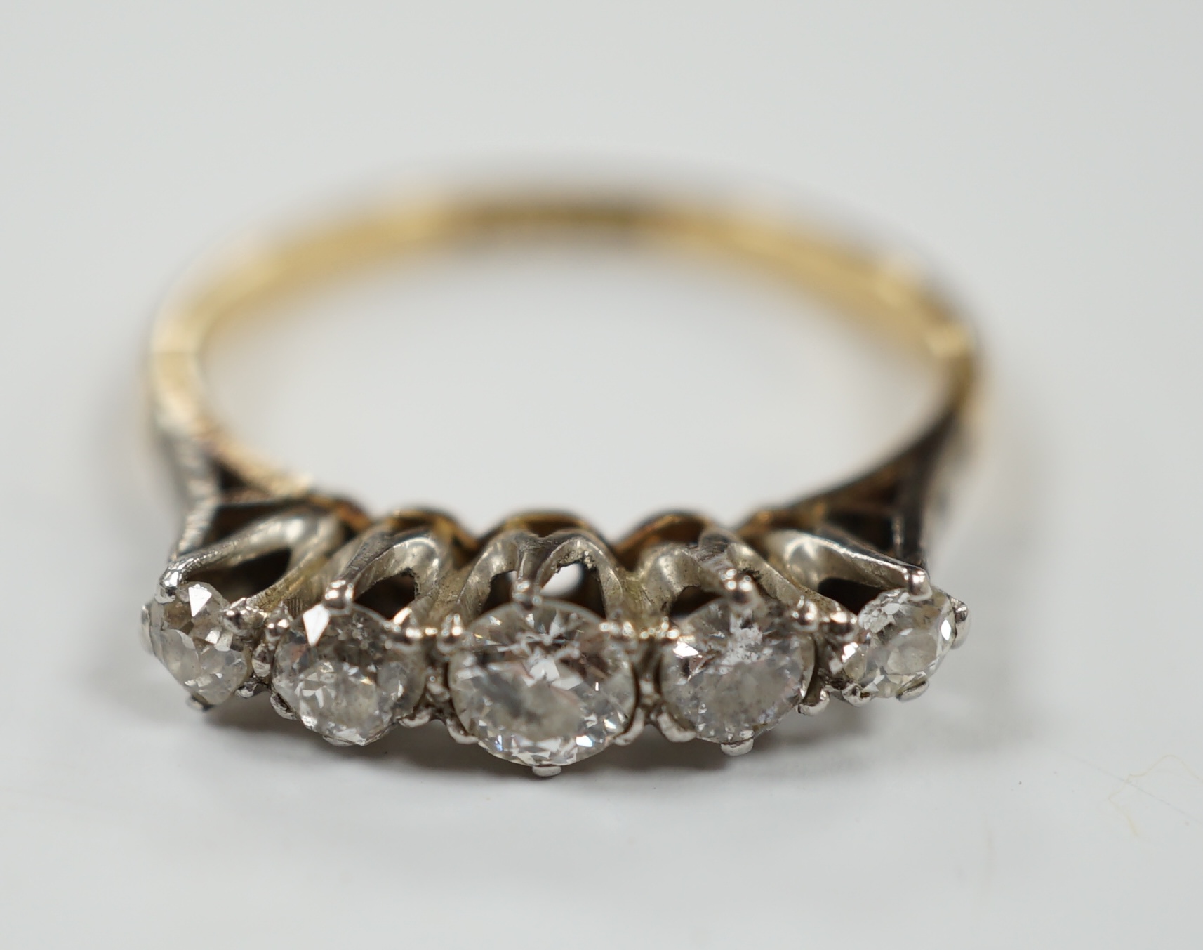An 18ct, plat. and graduated five stone diamond set half hoop ring, size P, gross weight 3.1 grams.